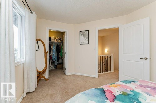 This room features soft carpeting, a window with curtains, and a closet with a bi-fold door - 2828 21 Avenue, Edmonton, AB - Indoor Photo Showing Bedroom