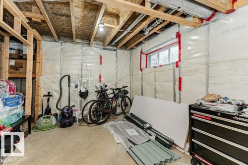 Unfinished basement area featuring exposed wooden ceiling joists, insulated walls, and a window for natural light - 2828 21 Avenue, Edmonton, AB - Indoor Photo Showing Basement