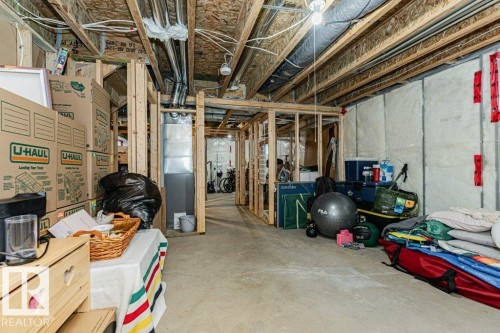 The property includes a spacious unfinished basement with exposed wooden beams, concrete flooring, and exposed ductwork - 2828 21 Avenue, Edmonton, AB - Indoor Photo Showing Basement