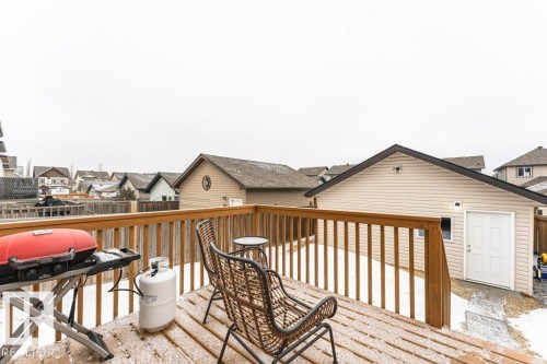 The property features a wooden deck with a wooden railing - 2828 21 Avenue, Edmonton, AB - Outdoor With Deck Patio Veranda With Exterior