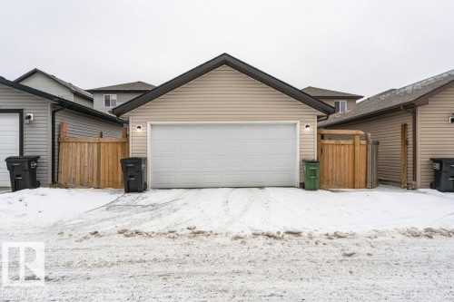 This property features a detached garage with a white garage door and beige siding - 2828 21 Avenue, Edmonton, AB - Outdoor With Exterior
