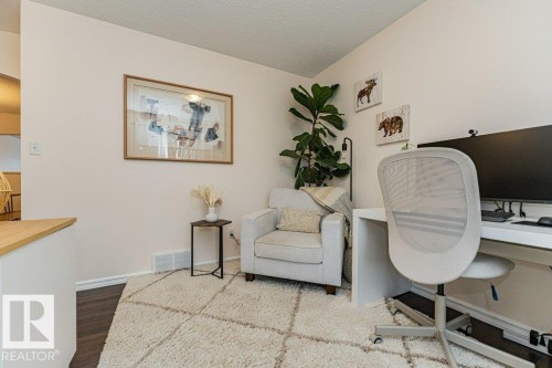 The property features light-colored walls and dark flooring, complemented by a textured area rug - 2828 21 Avenue, Edmonton, AB - Indoor Photo Showing Office