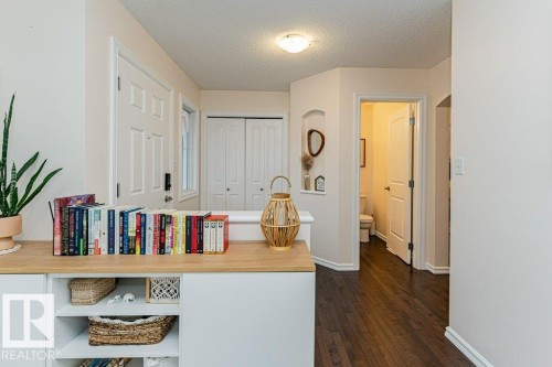The entryway features hardwood flooring, white doors, and a built-in shelving unit - 2828 21 Avenue, Edmonton, AB - Indoor Photo Showing Other Room