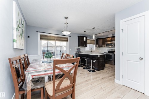 This spacious dining area features light-toned flooring and a sliding glass door - 35 675 Albany Way Nw, Edmonton, AB - Indoor Photo Showing Dining Room