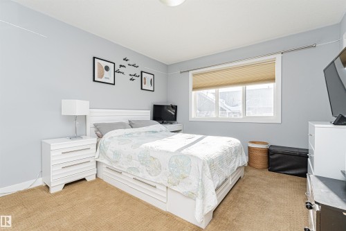 This room features a window with blinds, carpeted flooring, and light blue walls - 35 675 Albany Way Nw, Edmonton, AB - Indoor Photo Showing Bedroom