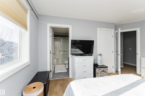 This room features light grey walls and a large window with blinds, providing natural light - 35 675 Albany Way Nw, Edmonton, AB - Indoor Photo Showing Bedroom