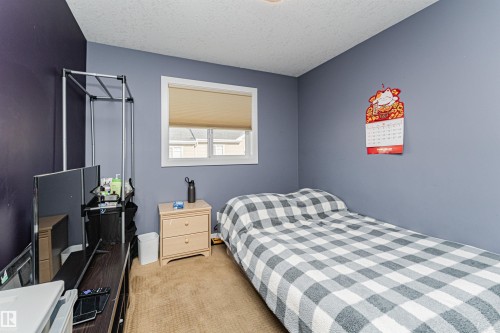 This room features a window with a roller blind, carpeted flooring, and walls with contrasting paint colors - 35 675 Albany Way Nw, Edmonton, AB - Indoor Photo Showing Bedroom