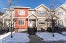 The property is a townhouse with a distinct red facade and white trim, featuring two levels of windows - 35 675 Albany Way Nw, Edmonton, AB  - Outdoor With Facade 