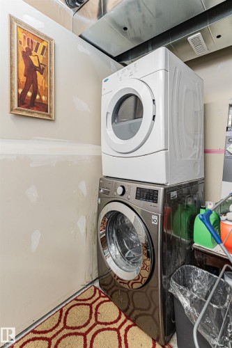 Dedicated laundry area featuring a white top-loading dryer and a metallic front-loading washing machine - 35 675 Albany Way Nw, Edmonton, AB - Indoor Photo Showing Laundry Room