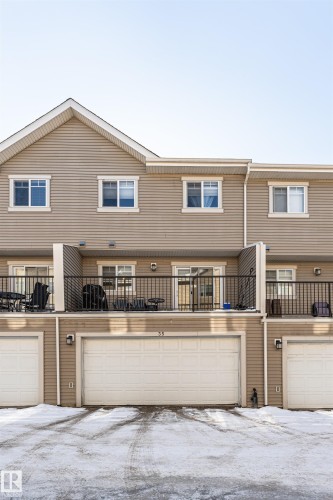 This property features a beige exterior with horizontal siding and white trim - 35 675 Albany Way Nw, Edmonton, AB - Outdoor With Balcony With Exterior