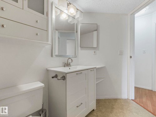 White vanity with integrated sink and chrome faucet - 143 10636 120 Street Nw, Edmonton, AB - Indoor