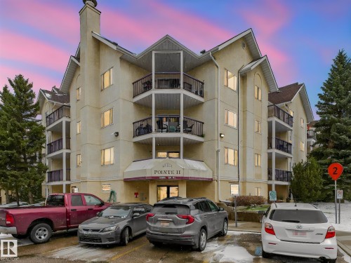 Multi-story condominium building featuring a light-colored stucco exterior with dark-framed balconies - 143 10636 120 Street Nw, Edmonton, AB - Outdoor