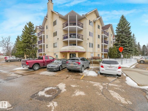 Multi-story building featuring balconies with metal railings, a sloped roofline, and a prominent entrance canopy - 143 10636 120 Street Nw, Edmonton, AB - Outdoor With Facade