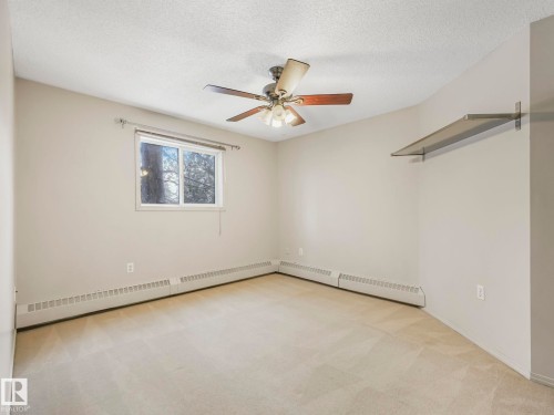 Neutral-toned wall paint complements the light-colored carpeting - 143 10636 120 Street Nw, Edmonton, AB - Indoor Photo Showing Other Room