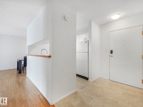 Entryway featuring a solid core door with digital lock, ceramic tile flooring, and overhead flush-mount lighting - 143 10636 120 Street Nw, Edmonton, AB - Indoor Photo Showing Other Room