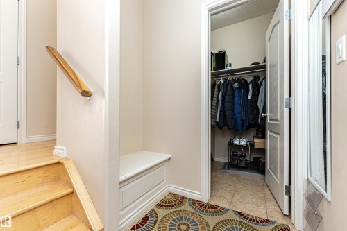 Entryway featuring wood-finish flooring, a built-in bench with storage, and a coat closet with shelving - 1915 126 Street, Edmonton, AB - Indoor Photo Showing Other Room