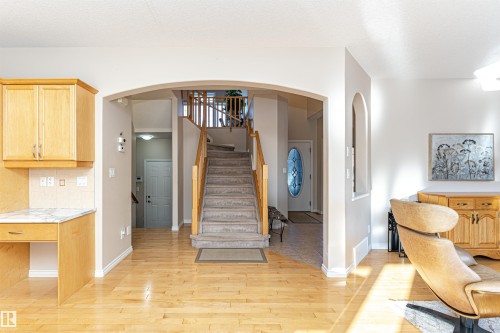 Grand entryway featuring a staircase with wood railings and carpeted treads - 1915 126 Street, Edmonton, AB - Indoor