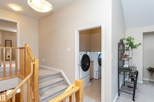 Dedicated laundry area featuring a front-loading washer and dryer, tile flooring, and overhead lighting - 1915 126 Street, Edmonton, AB - Indoor Photo Showing Other Room