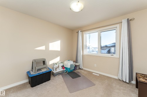 Carpeted room featuring a double window with casing and trim - 1915 126 Street, Edmonton, AB - Indoor