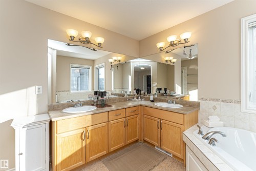 Dual vanity featuring light wood-finish cabinetry and light-toned countertops - 1915 126 Street, Edmonton, AB - Indoor Photo Showing Bathroom