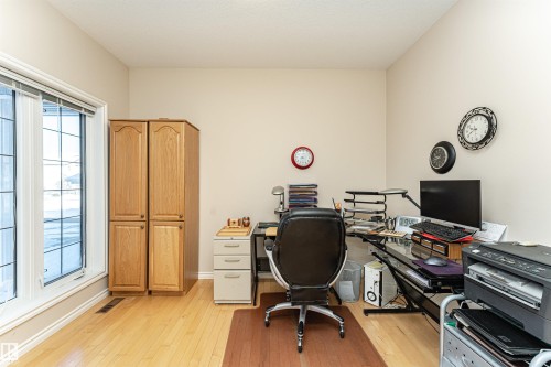 Bright room with expansive windows, light wood-finish flooring, and built-in wood cabinetry - 1915 126 Street, Edmonton, AB - Indoor Photo Showing Office
