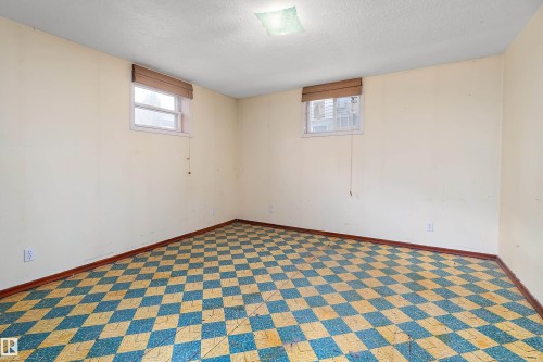 Room featuring a checkerboard floor pattern, two windows with blinds, light-toned walls, and a ceiling-mounted light fixture - 10124 88 Avenue, Edmonton, AB - Indoor Photo Showing Other Room