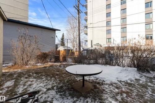 Expansive backyard space featuring a round patio foundation and a wood plank fence - 10124 88 Avenue, Edmonton, AB - Outdoor