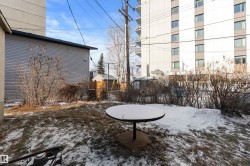 Expansive backyard space featuring a round patio foundation and a wood plank fence - 