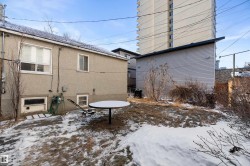 Stucco exterior featuring multiple windows and a detached outbuilding - 