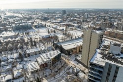 Expansive aerial perspective showcasing a dense urban environment with a mix of residential and commercial buildings - 
