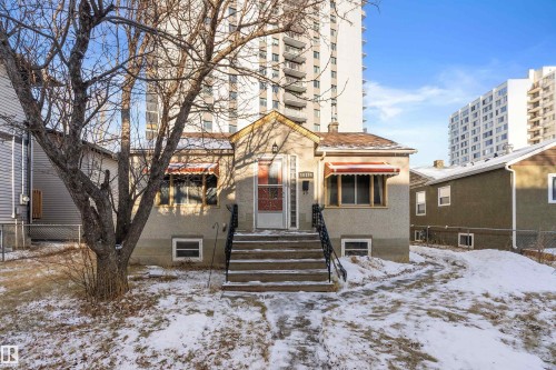 Stucco exterior with a peaked roofline and front entry porch - 10124 88 Avenue, Edmonton, AB - Outdoor With Facade