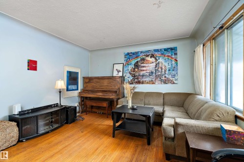 Hardwood flooring, light blue wall paint, multiple windows, and a built-in entertainment console - 10124 88 Avenue, Edmonton, AB - Indoor Photo Showing Other Room