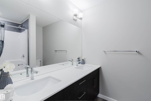 Dual sink vanity featuring white countertops, chrome faucets, and dark wood-finish cabinetry - 343 Edgemont Drive, Edmonton, AB - Indoor Photo Showing Bathroom