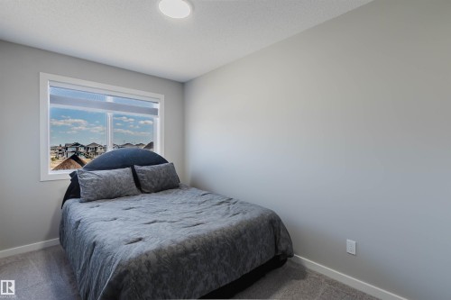 Bright interior space featuring a window with white trim, light gray walls, and plush gray carpeting - 343 Edgemont Drive, Edmonton, AB - Indoor Photo Showing Bedroom