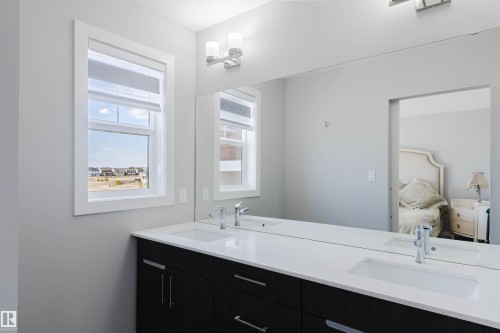 Double vanity featuring dark wood-finish cabinetry, white countertops, and integrated rectangular sinks with chrome fixtures - 343 Edgemont Drive, Edmonton, AB - Indoor Photo Showing Bathroom