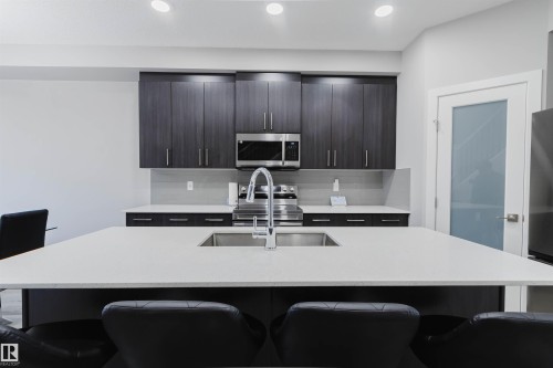 Kitchen island with white countertop and integrated sink - 343 Edgemont Drive, Edmonton, AB - Indoor Photo Showing Kitchen With Upgraded Kitchen