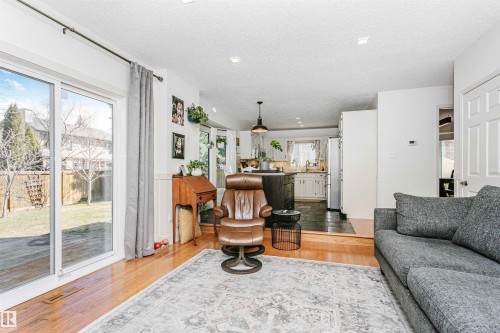 Open-concept living space featuring wood-finish flooring, recessed lighting, and a sliding glass door to the exterior - 17820 57 Avenue, Edmonton, AB - Indoor Photo Showing Living Room