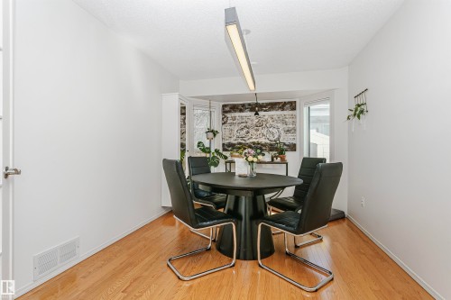 Dining area featuring wood-finish flooring and a bay window - 17820 57 Avenue, Edmonton, AB - Indoor Photo Showing Dining Room