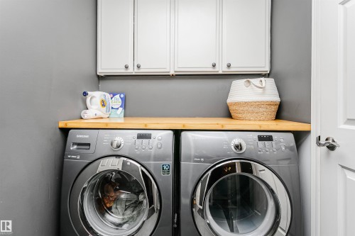 Dedicated laundry area featuring a wood-finish countertop - 17820 57 Avenue, Edmonton, AB - Indoor Photo Showing Laundry Room