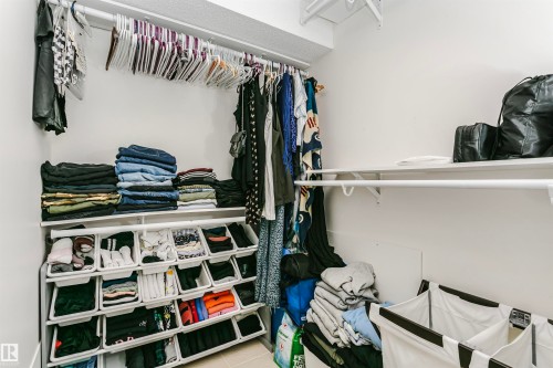 Built-in closet shelving system with multiple hanging rods and white walls - 17820 57 Avenue, Edmonton, AB - Indoor With Storage