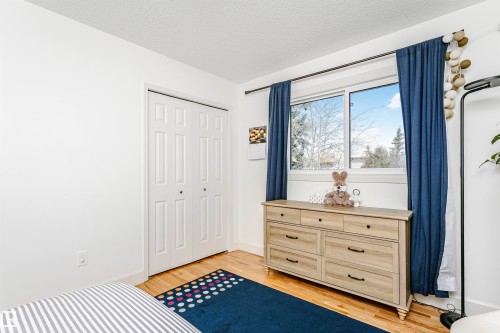 Hardwood flooring complemented by white baseboards and walls - 17820 57 Avenue, Edmonton, AB - Indoor Photo Showing Bedroom
