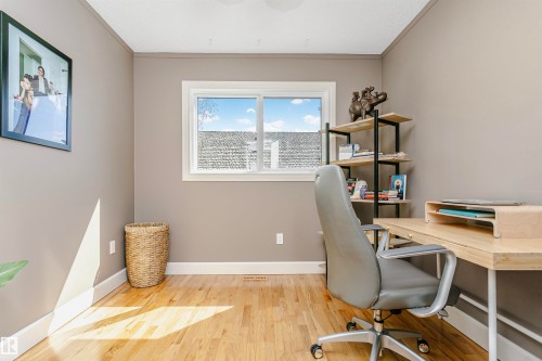 Bright room featuring a prominent window, light wood-finish flooring, neutral wall paint, and white trim - 17820 57 Avenue, Edmonton, AB - Indoor Photo Showing Office