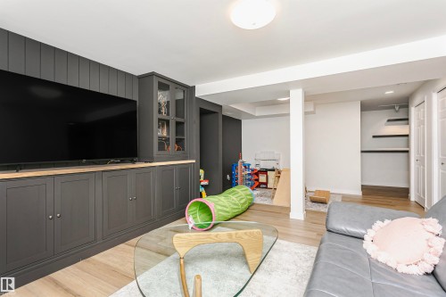 Entertainment area featuring a built-in media console with dark cabinetry and natural wood-finish countertops - 17820 57 Avenue, Edmonton, AB - Indoor