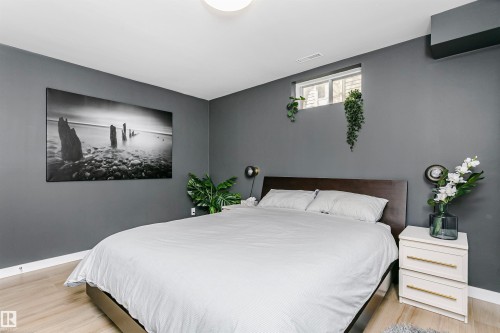 Bedroom featuring light wood-finish flooring, dark gray walls, and white baseboards - 17820 57 Avenue, Edmonton, AB - Indoor Photo Showing Bedroom