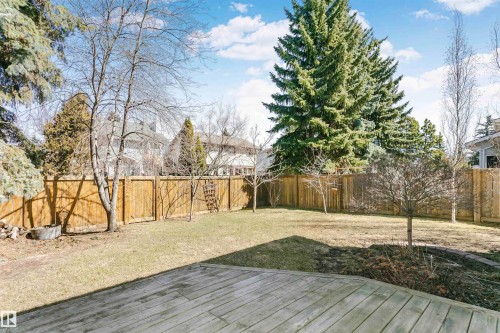 Spacious backyard featuring a wood deck, mature trees, manicured lawn, and a privacy fence - 17820 57 Avenue, Edmonton, AB - Outdoor