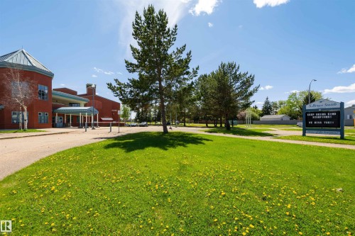 Red brick building with a curved façade and light blue accents - 17820 57 Avenue, Edmonton, AB - Outdoor With Deck Patio Veranda