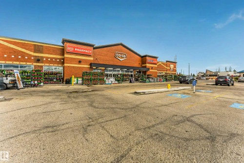 Retail storefront featuring a brick facade with large display windows - 17820 57 Avenue, Edmonton, AB - Outdoor With Deck Patio Veranda