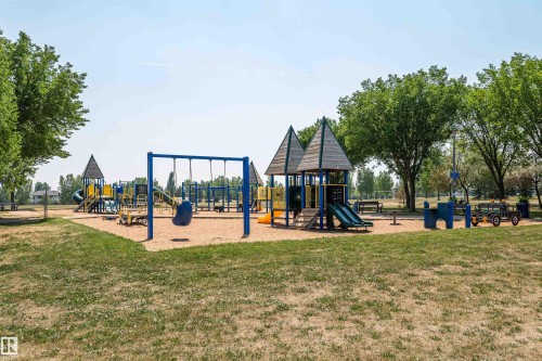 Community playground featuring multiple play structures with slides, swings, and climbing elements - 17820 57 Avenue, Edmonton, AB - Outdoor