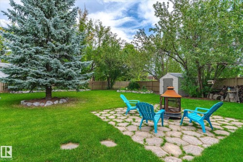 Expansive backyard featuring a lush lawn, mature trees, and a flagstone patio - 10339 36A Avenue, Edmonton, AB - Outdoor With Backyard