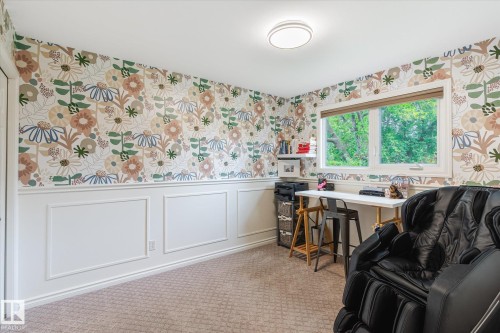 Room featuring a large window, patterned wallpaper, white wainscoting, and carpet flooring - 10339 36A Avenue, Edmonton, AB - Indoor